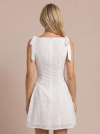 Vestido corto bordado con lazadas